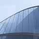 Wavy glass and steel roof of a modern building seen from below